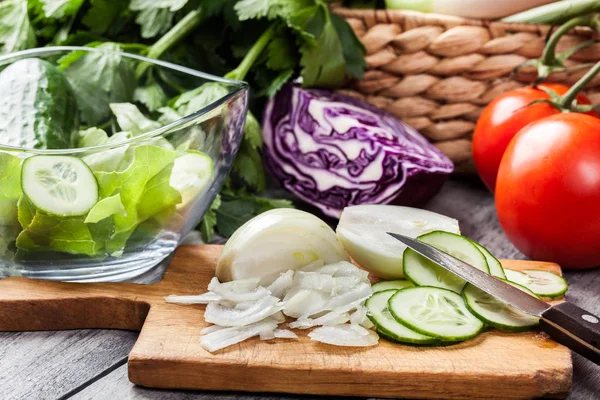 Gehakte groenten: UI en komkommer op snijplank — Stockfoto