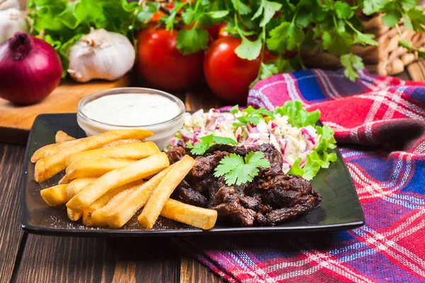 Кебаб из говядины с картошкой фри и салатом — стоковое фото