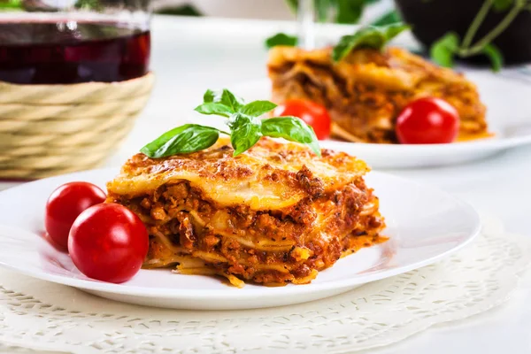 Stuk van lekkere warme lasagne met rode win — Stockfoto
