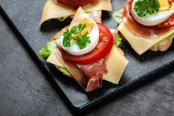 Delicioso sándwich con jamón de jamón, queso, tomate y huevo — Foto de Stock