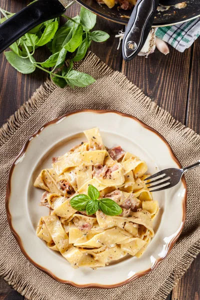 Bir plaka üzerinde jambon ve peynir soslu Pappardelle makarna — Stok fotoğraf