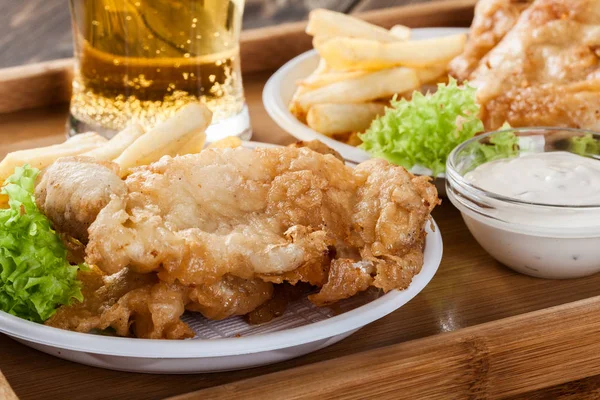 Peixe e batata frita com molho tártaro em uma bandeja — Fotografia de Stock