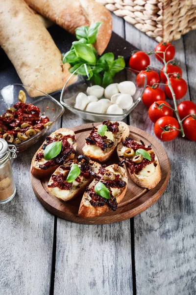 Vorspeise Bruschetta mit sonnengetrockneten Tomaten, Oliven und Mozarel — Stockfoto