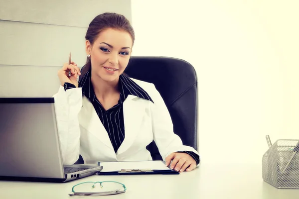 Aantrekkelijke zakenvrouw werken met de laptop op het kantoor — Stockfoto