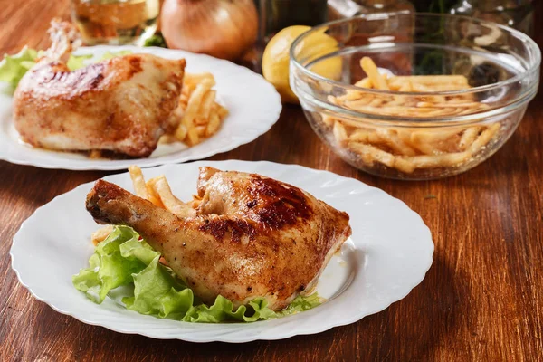 Roasted chicken legs with french fries and lettuce — Stock Photo, Image