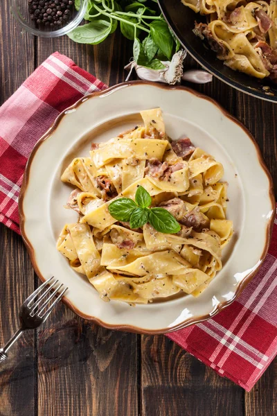 Pappardelle pasta med parmaskinka och ost på en tallrik — Stockfoto