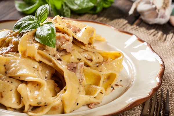 Massa de pappardelle com molho de queijo e prosciutto em um prato — Fotografia de Stock