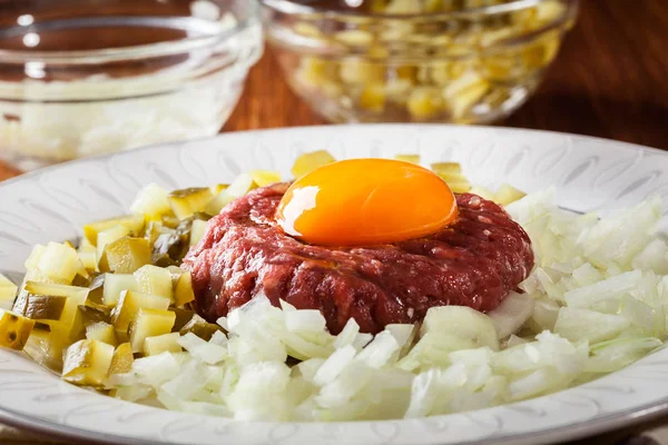 Filete tartar con yema de huevo, cebollas y encurtidos — Foto de Stock