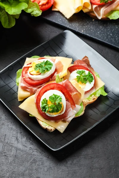 Delicioso sándwich con jamón de jamón, queso, tomate y huevo — Foto de Stock