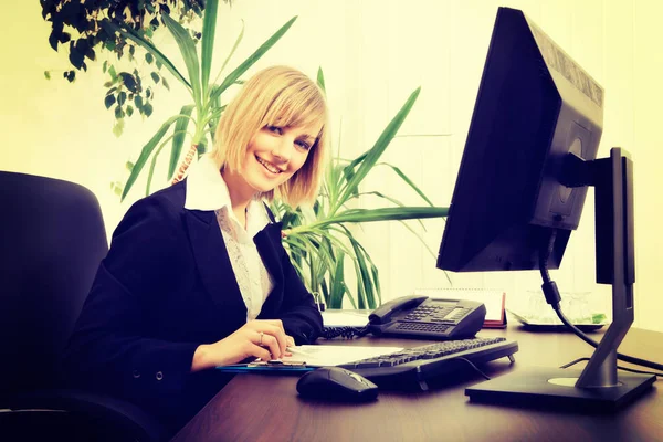 Mujer de negocios rubia trabajando en la computadora en la oficina —  Fotos de Stock