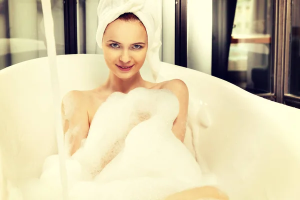 Mladá krásná zrzavá žena bere perličková koupel — Stock fotografie