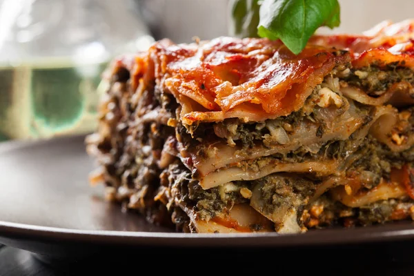 Kus chutné horké lasagne se špenátem na talíři — Stock fotografie