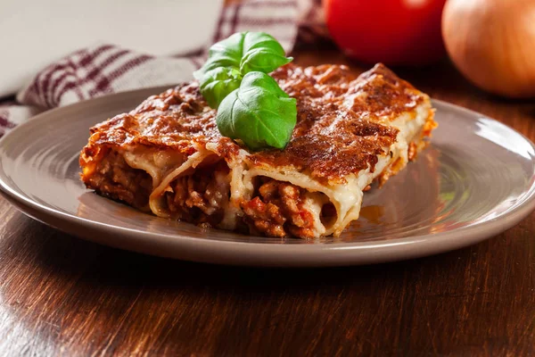 Zapečené cannelloni s mletým masem a bešamelovou omáčkou na talíři — Stock fotografie