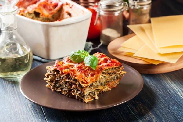 Kus chutné horké lasagne se špenátem na talíři — Stock fotografie