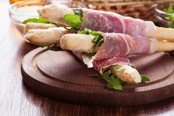 Italian grissini with ham prosciutto, mozzarella and arugula — Stock Photo, Image