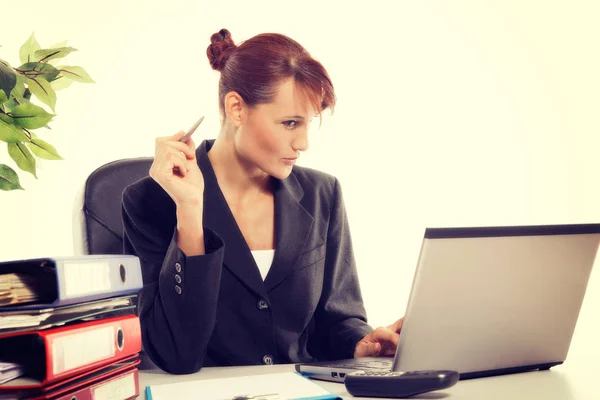 Young attractive business woman using laptop at the office Royalty Free Stock Images