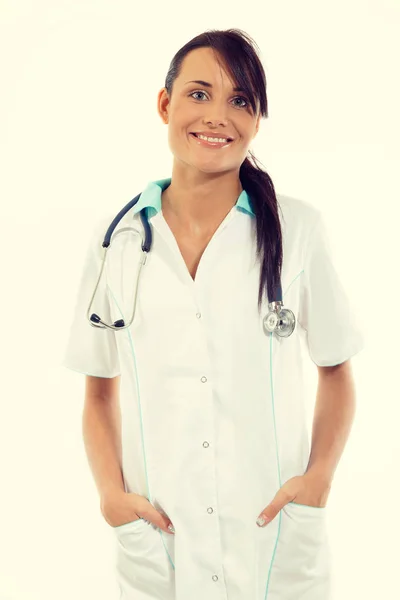 Médecin femme avec stéthoscope debout au bureau et souriant à la caméra — Photo