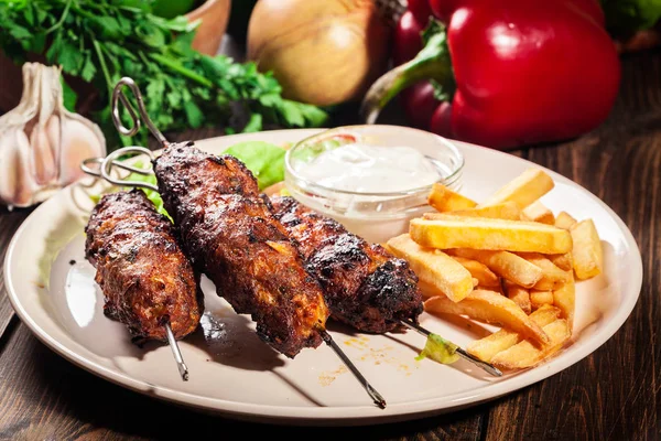 Gegrilde shish kebab geserveerd met gebakken frites en salade — Stockfoto