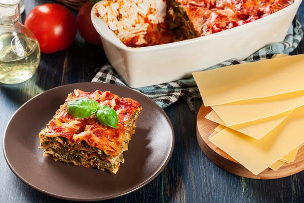 Kawałek smaczne gorące Lasagne ze szpinakiem na talerzu — Zdjęcie stockowe