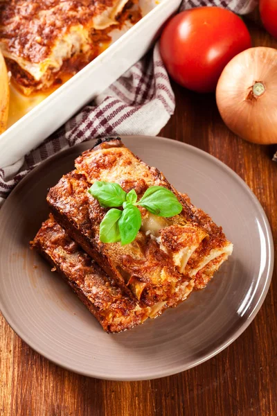 Canelones al horno con carne picada y salsa de bechamel en un plato —  Fotos de Stock