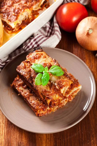 Zapečené cannelloni s mletým masem a bešamelovou omáčkou na talíři — Stock fotografie