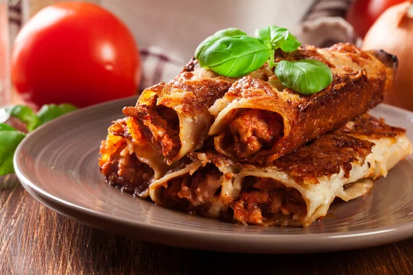 Bakad cannelloni med köttfärs och BECHAMELSÅS på en tallrik — Stockfoto