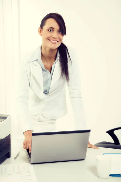 Jovem mulher de negócios atraente usando laptop no escritório — Fotografia de Stock