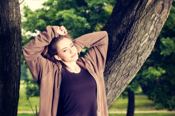 Mladá žena ve sportovním oblečení odpočívá v parku po ranní cvičení — Stock fotografie