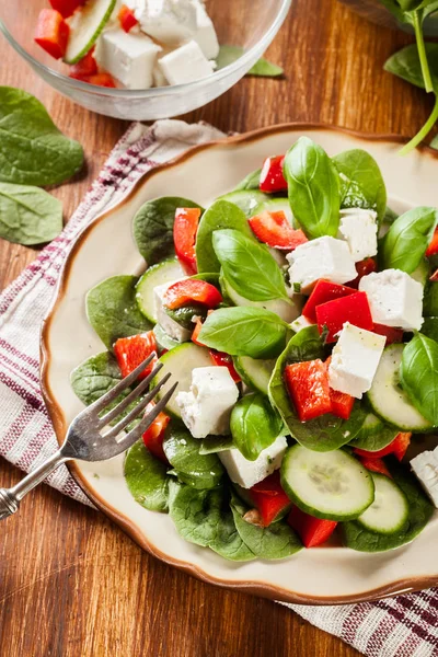 Frischer Spinatsalat mit Feta, Gurke und rotem Paprika auf einer Pflaume — Stockfoto