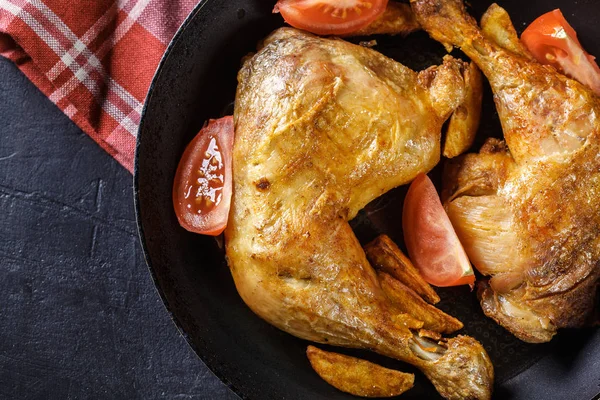 Gebraden kip benen met aardappel partjes en tomaten — Stockfoto