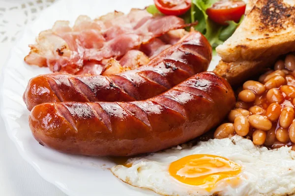 Englisches Frühstück mit Speck, Wurst, Spiegelei und gebackenen Bohnen — Stockfoto