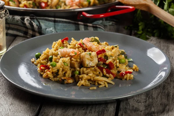 Paella tradicional de frutos do mar com camarão, peixe e frango costurados em prato . — Fotografia de Stock
