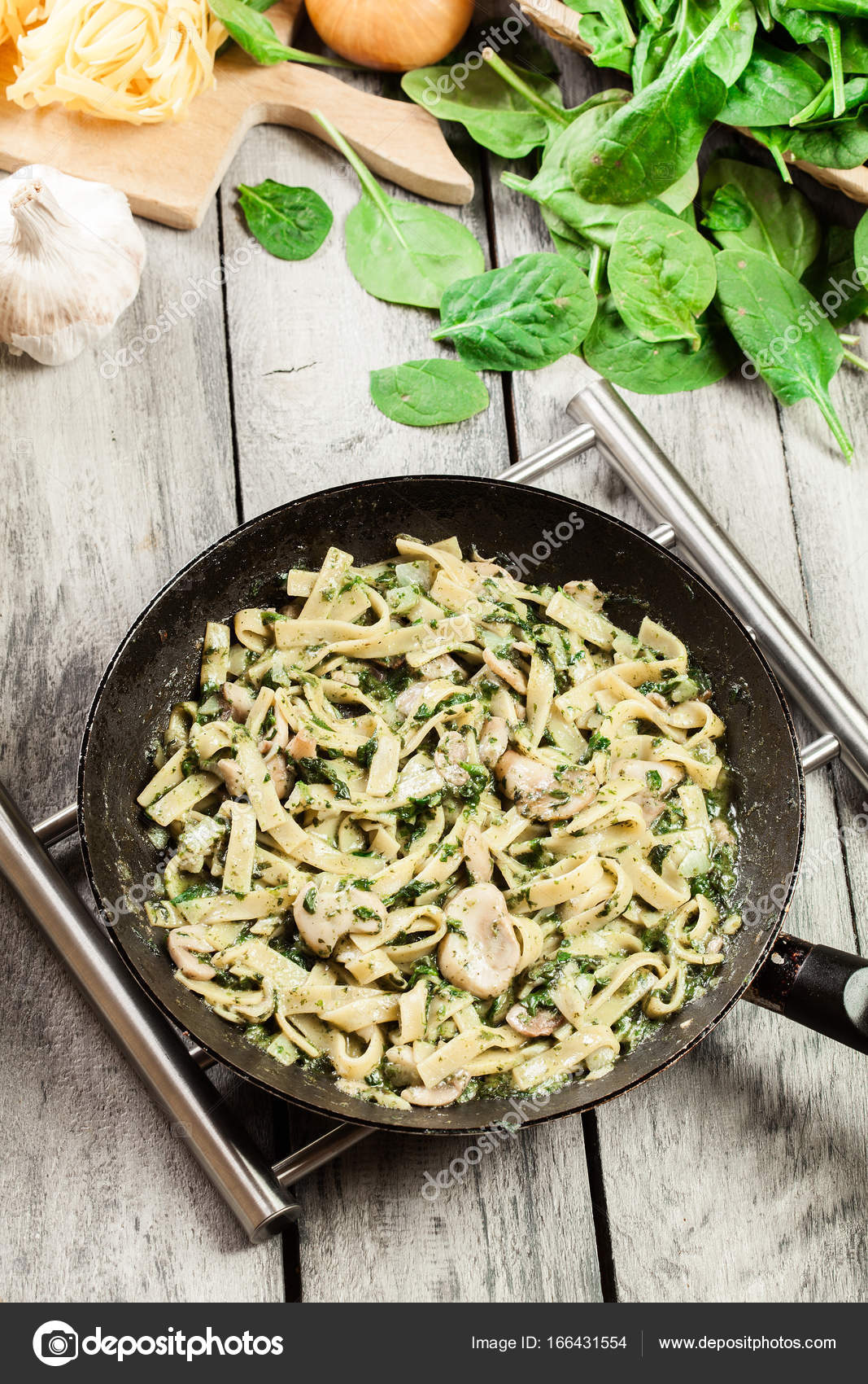 Tagliatelle pasta with spinach and mushrooms on a pan. — Stock Photo