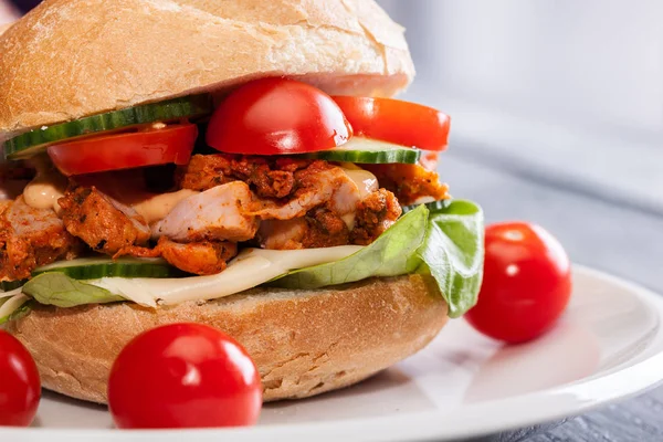 Fried chicken meat with cheese and vegetables in bun — Stock Photo, Image