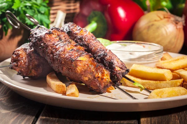 Grilled shish kebab served with fried chips and salad — Stock Photo, Image