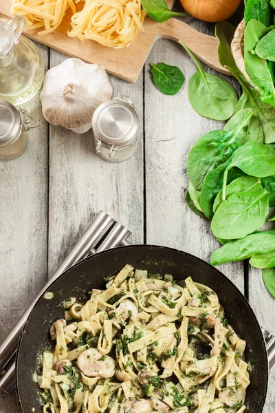 Tagliatelle Nudeln mit Spinat und Pilzen in einer Pfanne. — Stockfoto