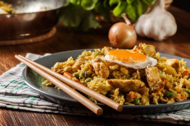 Fried rice nasi goreng with chicken egg and vegetables on a plate. clipart