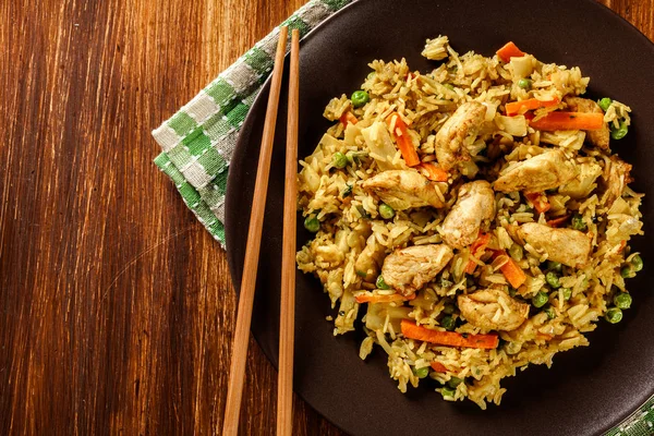 Смажений рис насі з куркою та овочами на тарілці — стокове фото