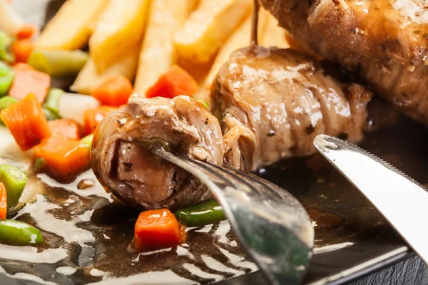 Closeup of a piece of pork rolls loaded on fork — Stock Photo, Image