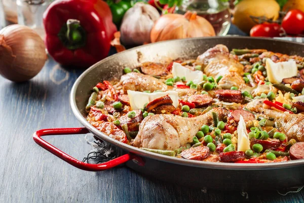V paellera podává tradiční paella s kuřecích stehen, chorizo klobásou a zeleninou — Stock fotografie