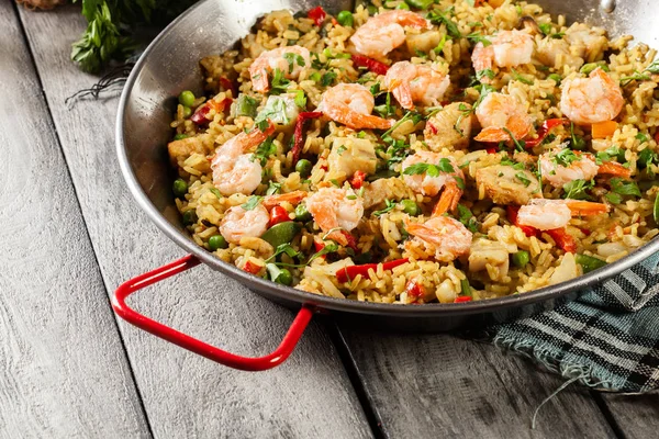 Traditional seafood paella with shrimp, fish and chicken seved in paellera — Stock Photo, Image
