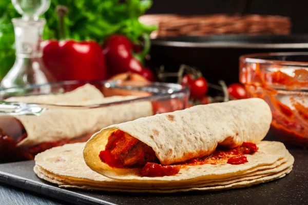 Příprava tradiční mexické enchiladas s kuřecím masem, pikantní rajčatovou omáčkou a sýrem — Stock fotografie