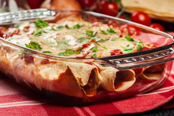 Traditional mexican enchiladas with chicken meat, spicy tomato sauce and cheese in heat resistant dish — Stock Image Traditional mexican enchiladas with chicken meat, spicy tomato sauce and cheese in heat resistant dish Stock Image
