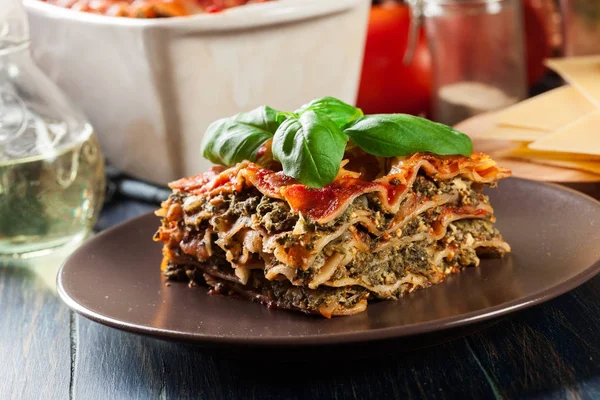 Kus chutné horké lasagne se špenátem na talíři — Stock fotografie