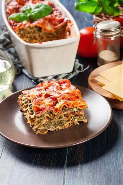 Piece of tasty hot lasagna with spinach on a plate — Stock Photo, Image