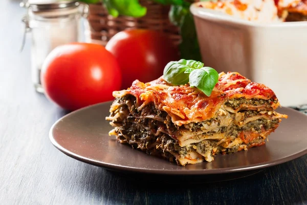 Bit av välsmakande varm lasagne med spenat på en tallrik — Stockfoto