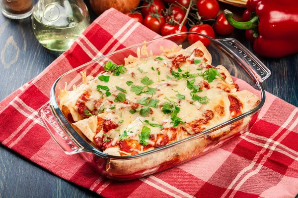 Traditional mexican enchiladas with chicken meat, spicy tomato sauce and cheese in heat resistant dish — Stock Image Traditional mexican enchiladas with chicken meat, spicy tomato sauce and cheese in heat resistant dish Stock Photo