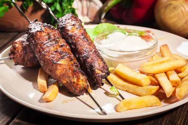 Kebab shish grelhado servido com batatas fritas e salada — Fotografia de Stock