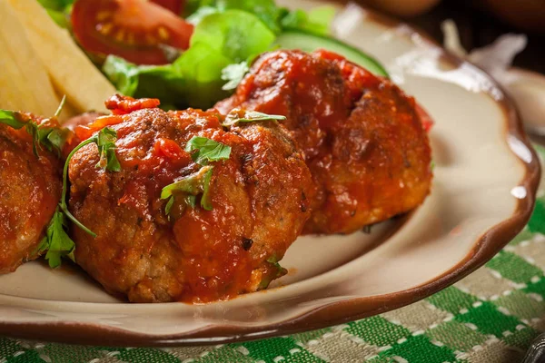 Gebratene Hackbällchen in Tomatensauce mit Pommes und Salat — Stockfoto