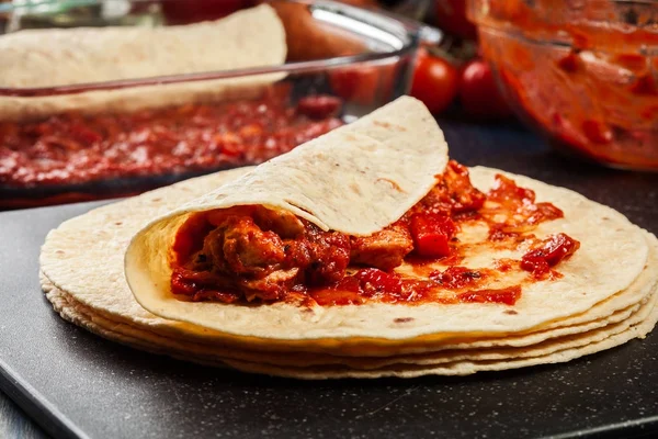 Παραδοσιακό μεξικάνικο enchiladas προετοιμασία με κρέας κοτόπουλου, πικάντικη σάλτσα ντομάτας και τυρί — Φωτογραφία Αρχείου